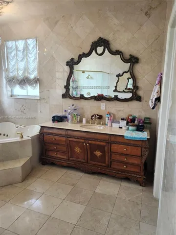 a white toilet sitting next to a white sink and vanity