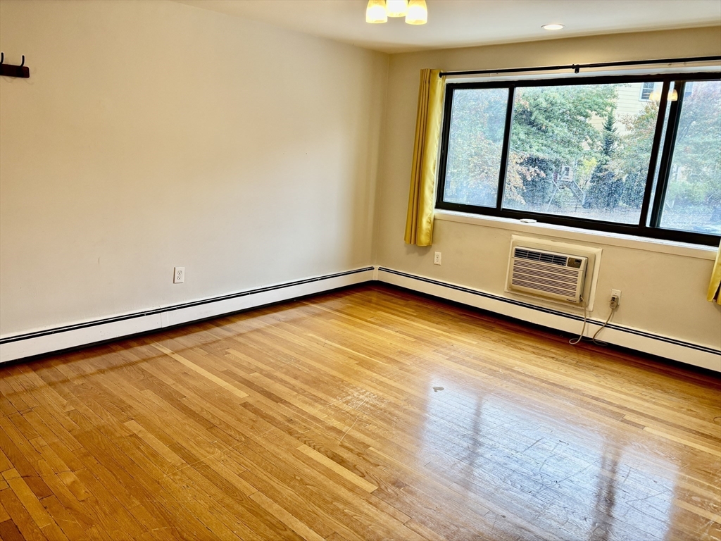 2192 Massachusetts Avenue, Unit 14 Cambridge, MA 02140 - Photo 3 of 19 a view of an empty room with wooden floor and a window