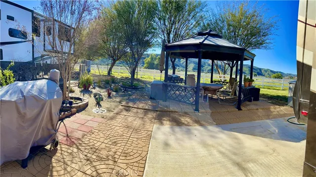 a view of a patio with a table and chairs under an umbrella