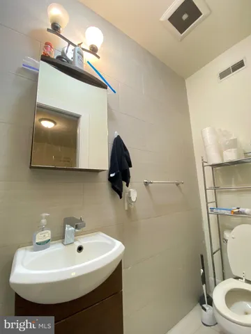a bathroom with a sink toilet and mirror