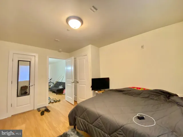 a bedroom with a bed and dresser with mirror