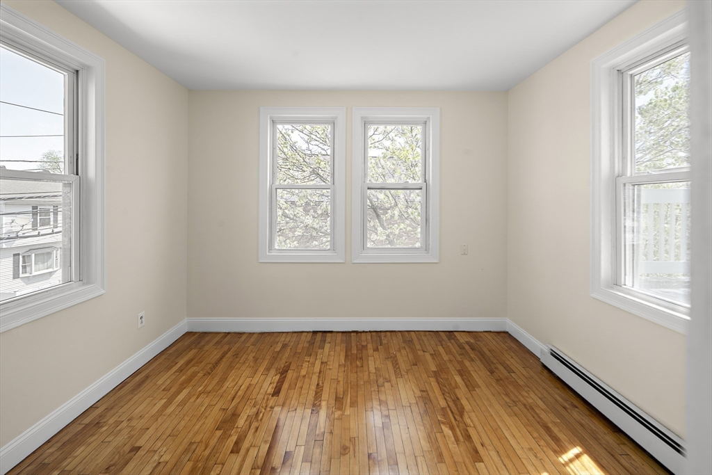 37 Union Street, Unit 2 Everett, MA 02149 - Photo 5 of 15 an empty room with wooden floor and windows
