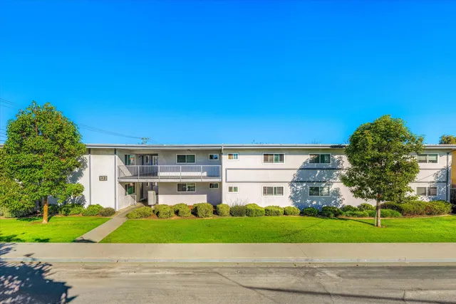 a view of a big building with a big yard and large trees