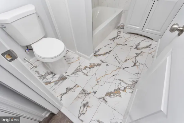 a white toilet sitting next to a shower curtain