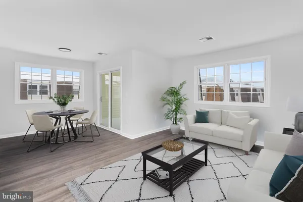 a living room with furniture a dining table and a window