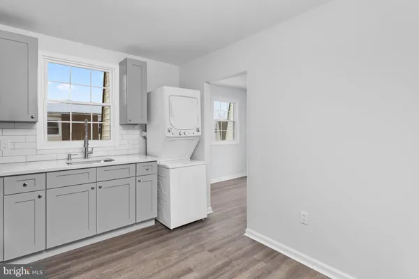 a kitchen with white cabinets and sink