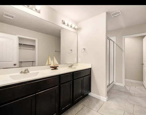 a bathroom with a double vanity sink a mirror and a