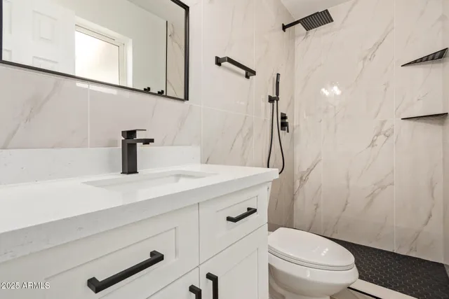 a bathroom with a sink a toilet and shower