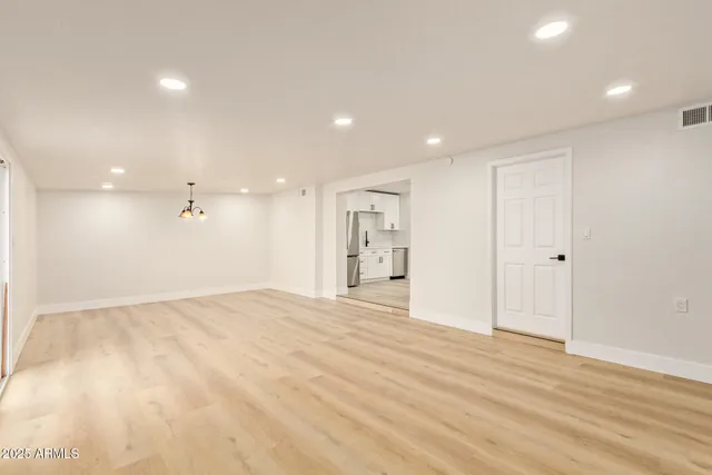 a view of an empty room with wooden floor
