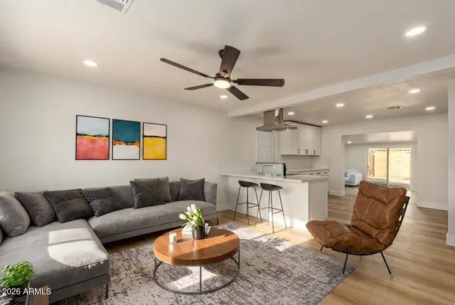 a living room with furniture and a view of kitchen