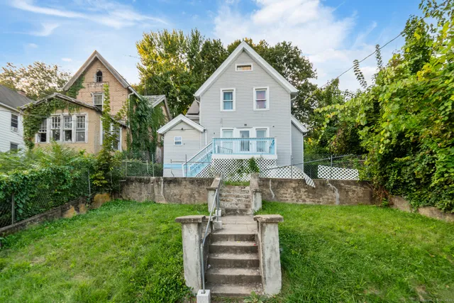 a front view of a house with a garden and plants