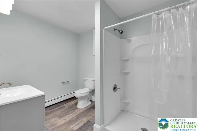 a bathroom with a sink a toilet and shower