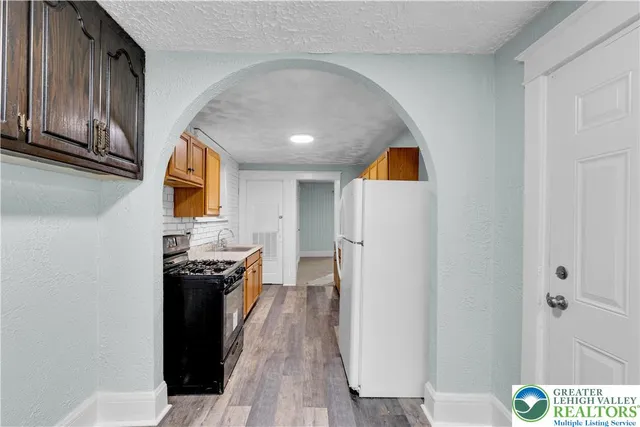 a kitchen with granite countertop a sink cabinets and wooden floor