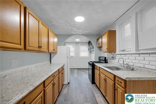 a kitchen with stainless steel appliances granite countertop sink stove microwave and cabinets