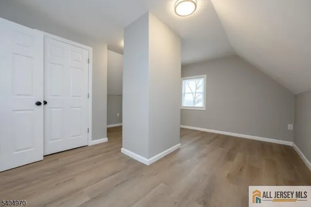 an empty room with wooden floor and window