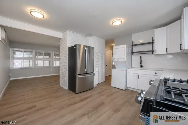 a kitchen with a refrigerator and a stove top oven