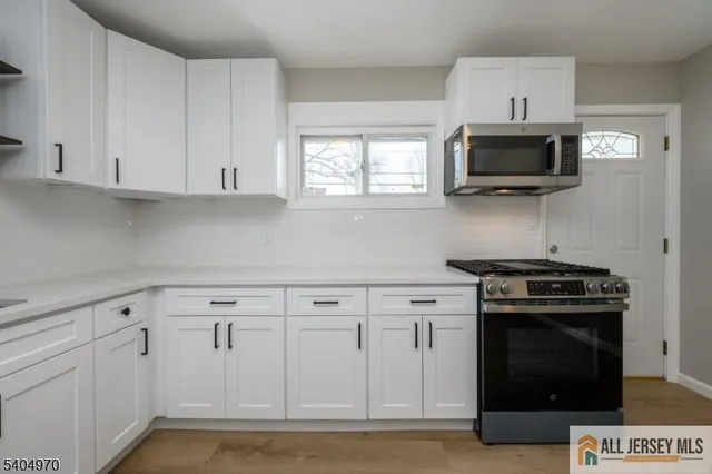 a kitchen with white cabinets and stainless steel appliances