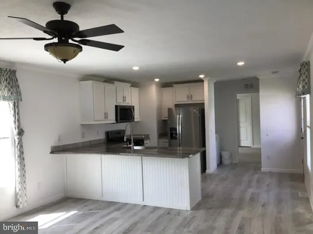 a kitchen with stainless steel appliances kitchen island granite countertop a refrigerator and a sink