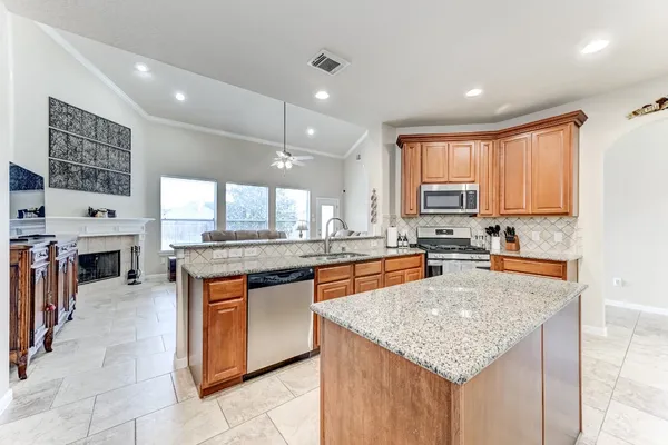 a kitchen with stainless steel appliances granite countertop a stove a sink a oven and a refrigerator