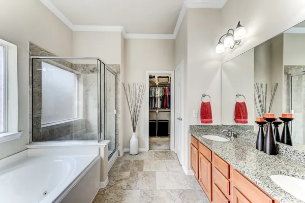 a spacious bathroom with a granite countertop sink mirror and bathtub
