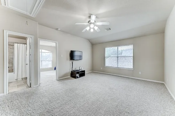 an empty room with windows and fan