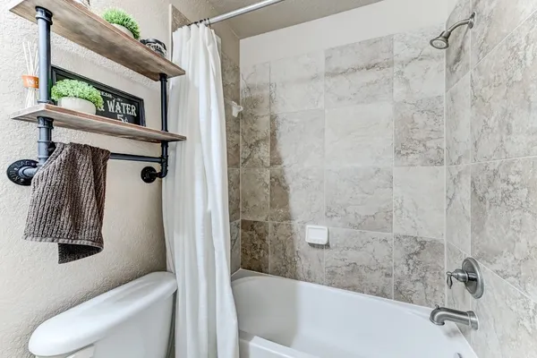 a bathroom with a toilet and a shower