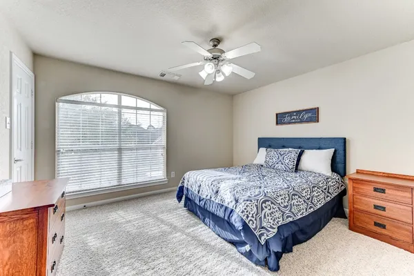 a bedroom with a bed and a large window