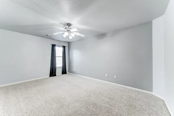 a view of an empty room with a chandelier fan