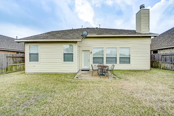 a backyard of a house with table and chairs