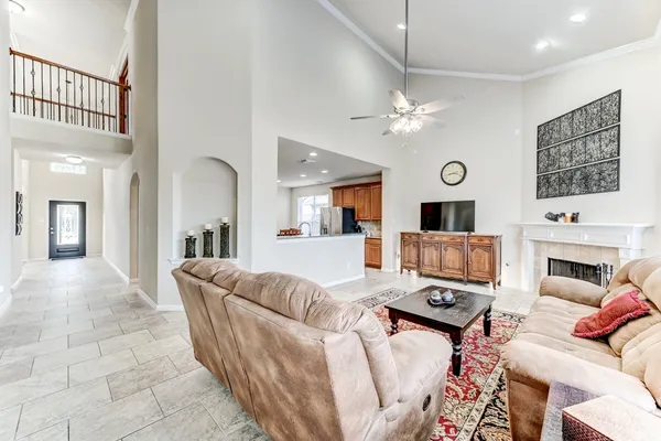a living room with furniture a fireplace and a ceiling fan