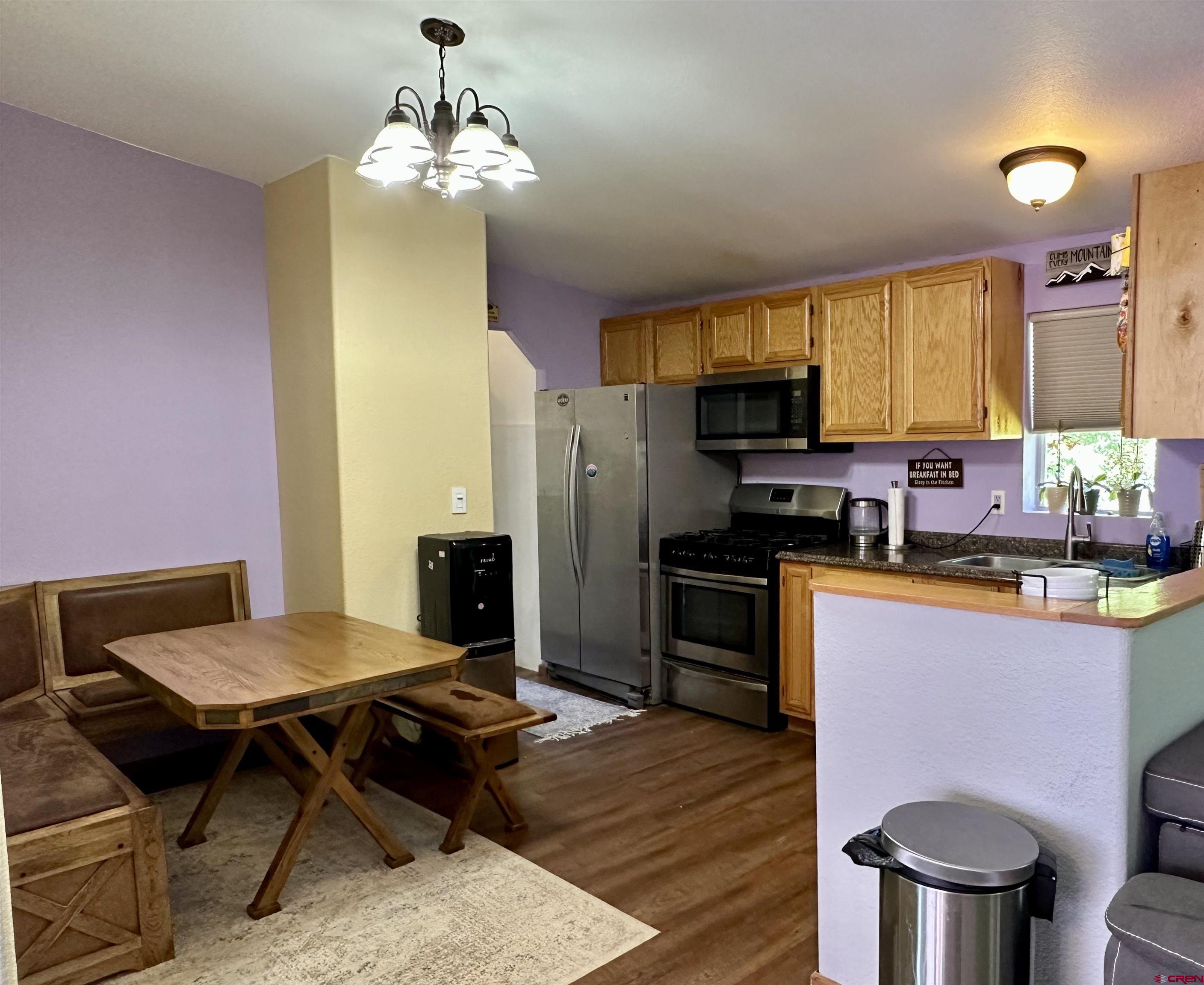 6000 County Road 203, Unit 55 Durango, CO 81301 - Photo 6 of 33 a kitchen with a stove refrigerator dining table and chairs