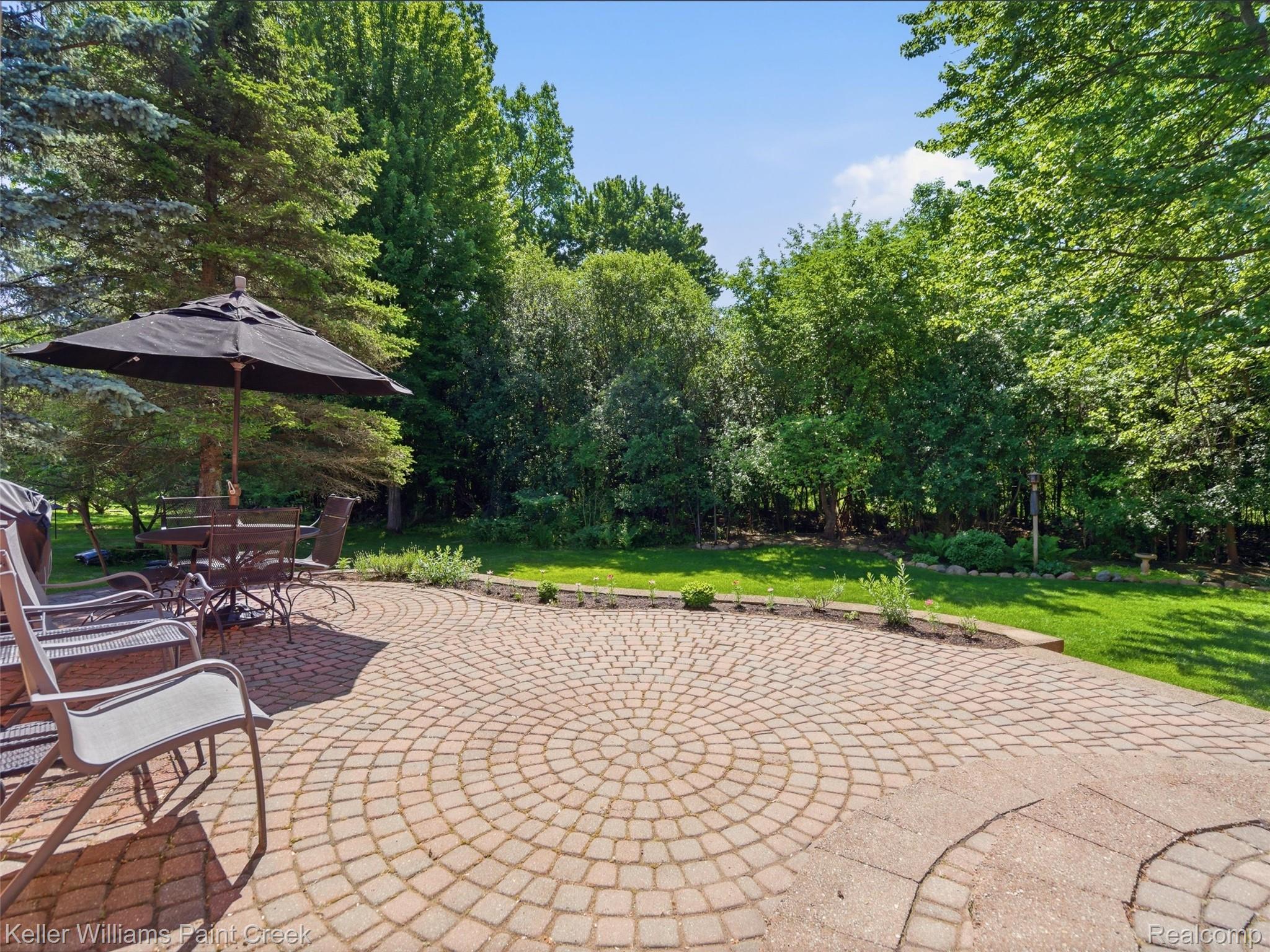 2842 Manorwood Road Troy, MI 48085 - Photo 71 of 72 Spacious brick paver patio featuring a circular pattern, bordered by a low retaining wall