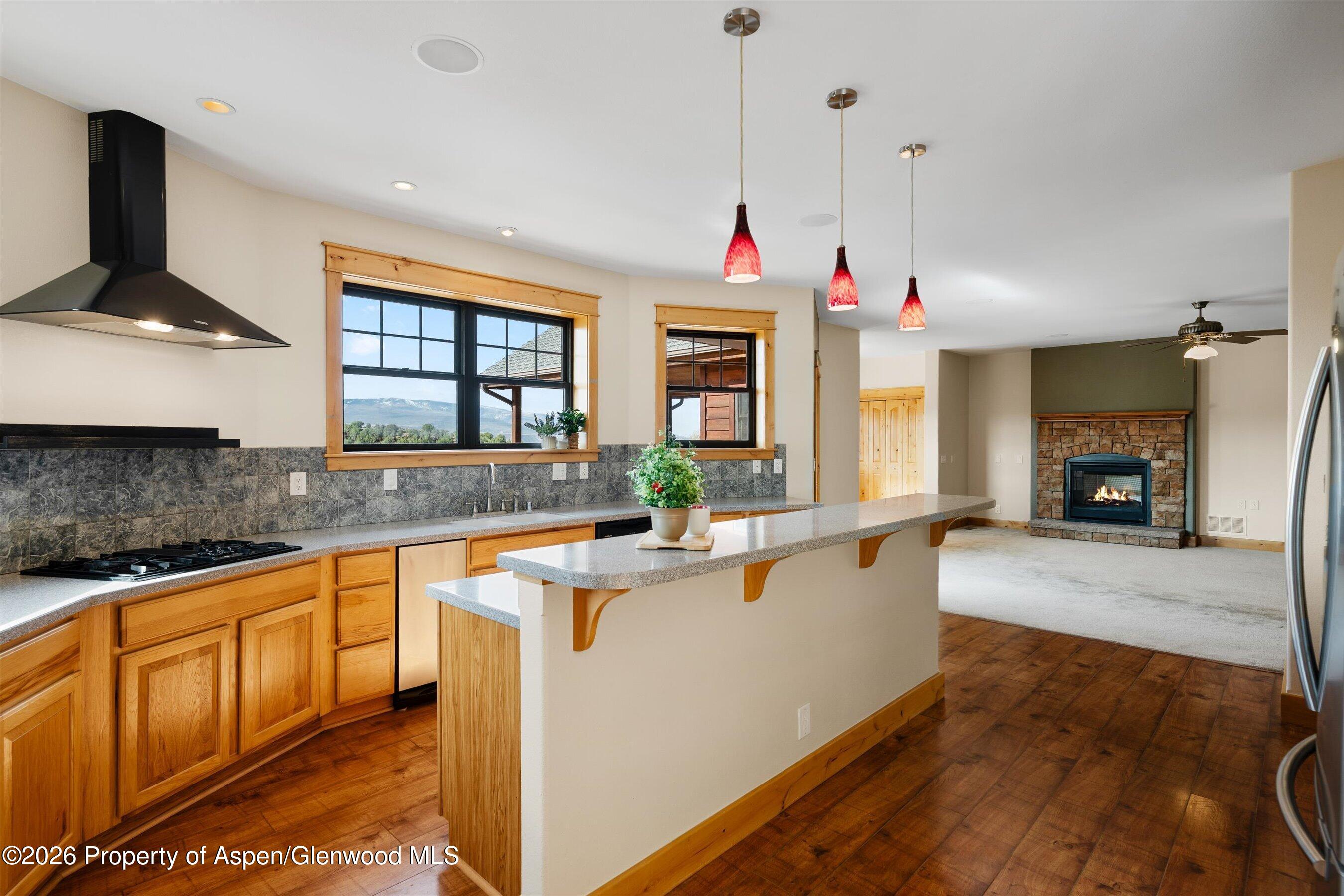 450 Summer Falls Road Silt, CO 81652 - Photo 8 of 50 a view of a kitchen with kitchen island a sink wooden floor and a counter top space