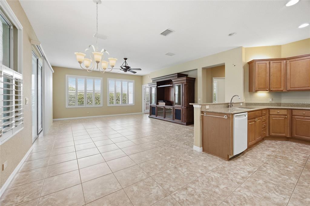 9029 Southeast 130th Loop Summerfield, FL 34491 - Photo 20 of 55 a kitchen with stainless steel appliances granite countertop a stove top oven a sink dishwasher a dining table and chairs with wooden floor