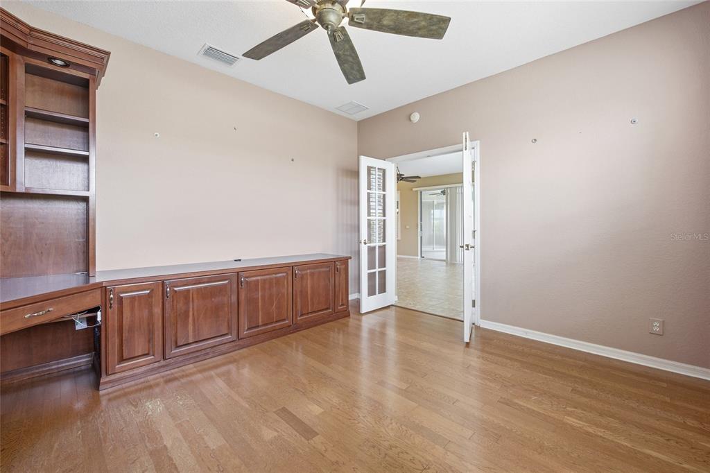 9029 Southeast 130th Loop Summerfield, FL 34491 - Photo 28 of 55 an empty room with wooden floor and cabinet