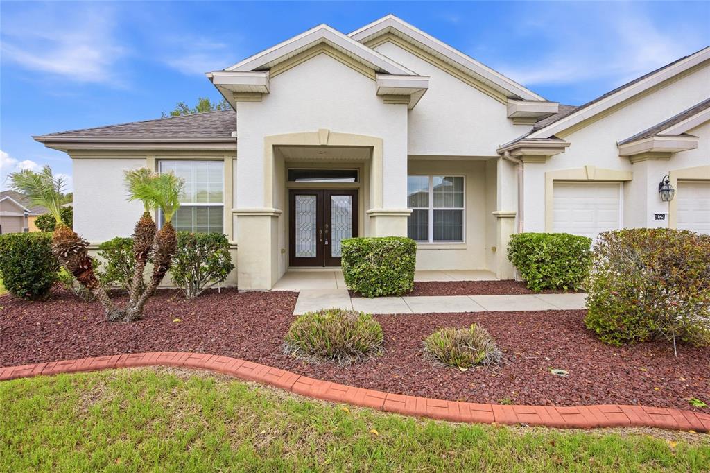 9029 Southeast 130th Loop Summerfield, FL 34491 - Photo 3 of 55 a front view of a house with garden