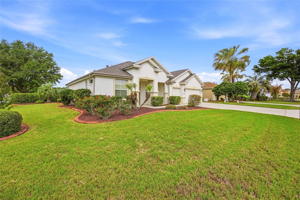 9029 Southeast 130th Loop Summerfield, FL 34491 - Photo 4 of 55 a front view of a house with a garden and yard