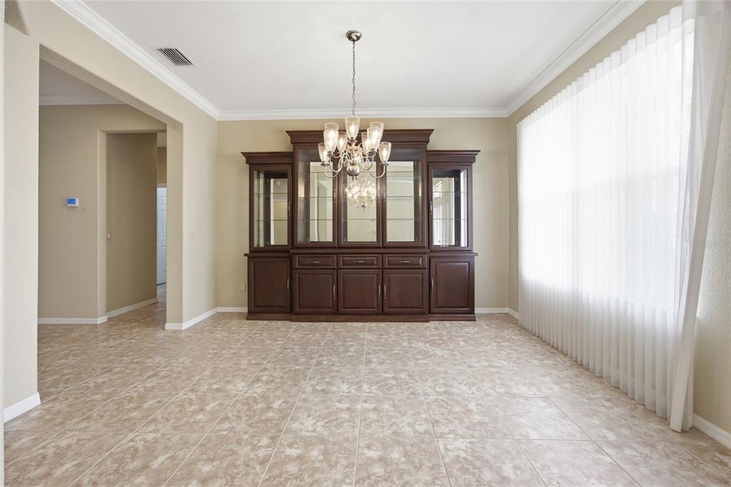 9029 Southeast 130th Loop Summerfield, FL 34491 - Photo 7 of 55 an empty room with chandelier and windows