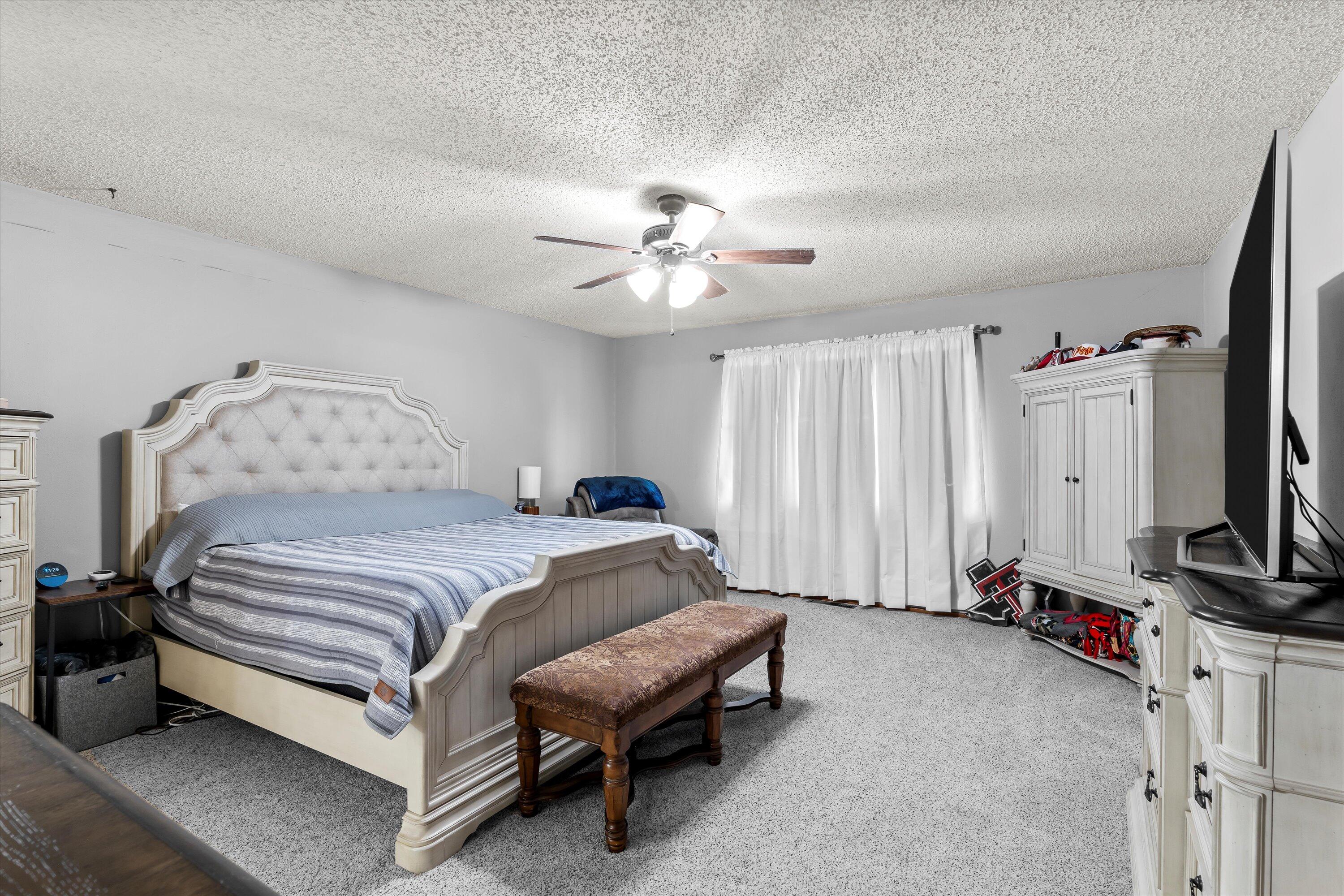 116 East 26th Street Littlefield, TX 79339 - Photo 18 of 40 a bedroom with a bed and a chandelier