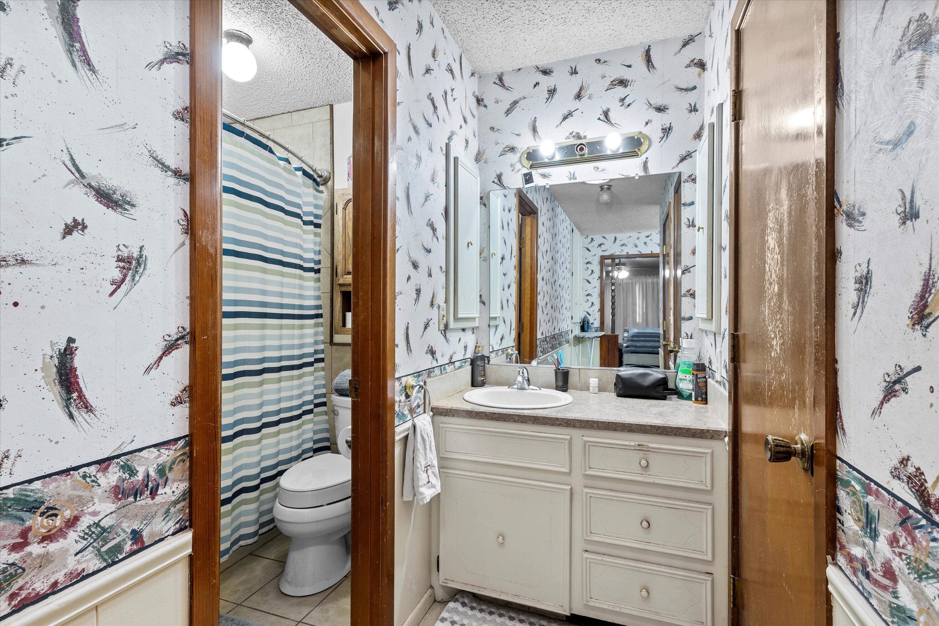 116 East 26th Street Littlefield, TX 79339 - Photo 21 of 40 a bathroom with a toilet sink and mirror