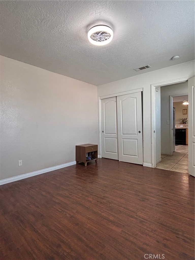 14980 Pendleton Street Hesperia, CA 92345 - Photo 23 of 27 a view of an empty room with wooden floor and a window