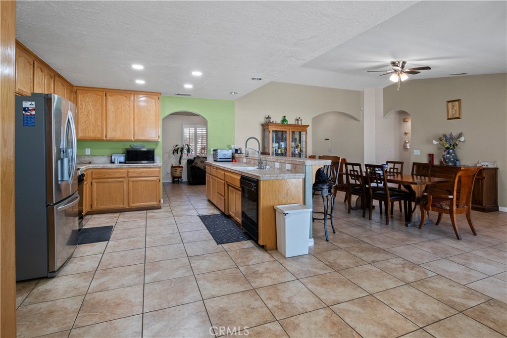 14980 Pendleton Street Hesperia, CA 92345 - Photo 10 of 27 a living room with furniture a dining table and a refrigerator