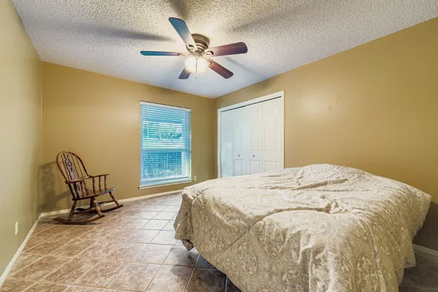 a bedroom with a bed a chair and a window