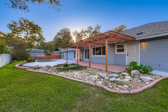 a view of a house with a yard and potted plants