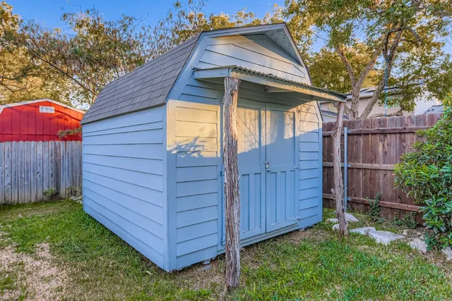 a view of a small house with wooden fence