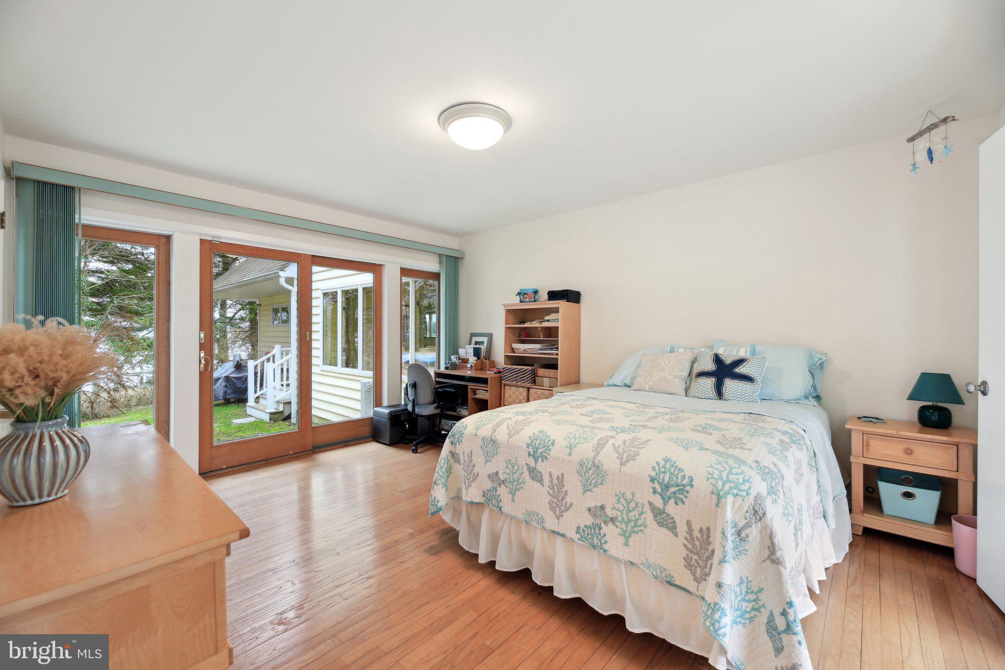 1601 Cliff Drive Edgewater, MD 21037 - Photo 37 of 86 a bedroom with a large bed and a large window with wooden floor