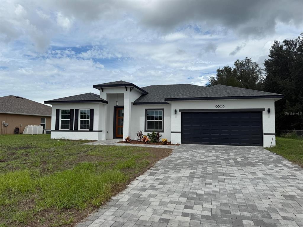 6603 Southwest 129th Street Ocala, FL 34473 - Photo 1 of 1 a front view of a house with a yard and garage