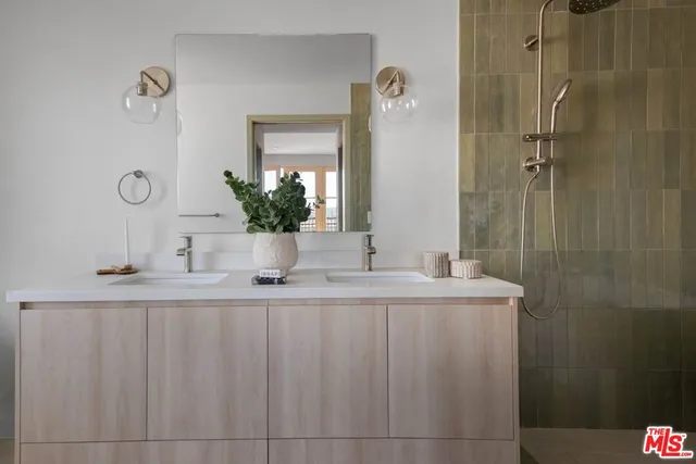 a bathroom with a granite countertop sink a mirror and shower