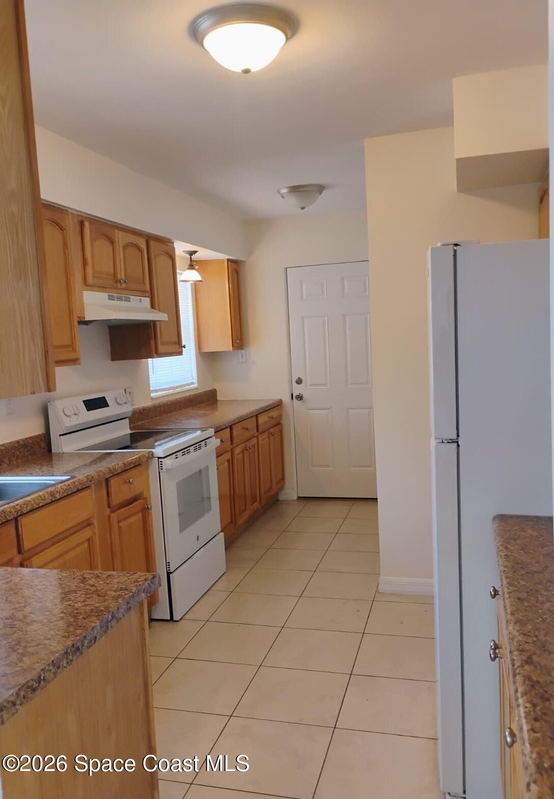 2310 Reef Avenue Indialantic, FL 32903 - Photo 4 of 13 a kitchen with stainless steel appliances granite countertop a stove a sink and a refrigerator