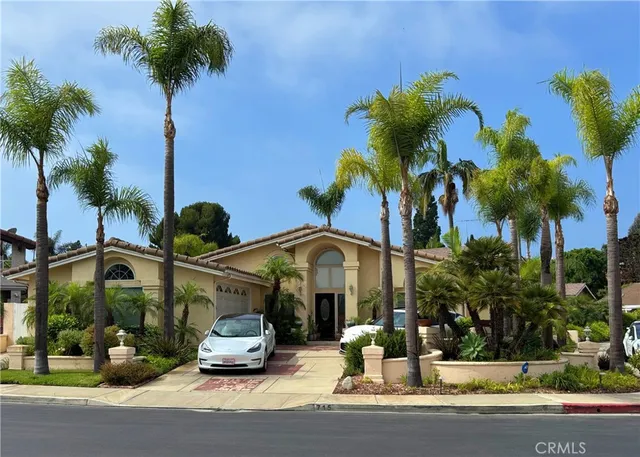 a car parked in front of a house with potted plants